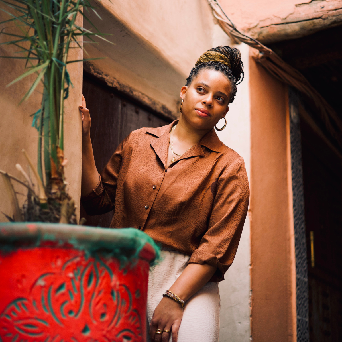 Joy Poses With Plant in an Alley in the Medina